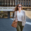 Frau mit Sonnenbrille und Handtasche über der Schulter