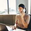 Woman on the laptop makes phone calls and answers inquiries automatically