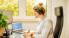 Frau die am Schreibtisch sitzt und arbeitet