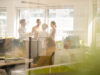 Eine Gruppe von Kolleginnen und Kollegen bei einer Besprechung im hellen Büro