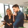 Frau und Mann die sich auf Tablet über den AI Act für Immobilienmakler informieren